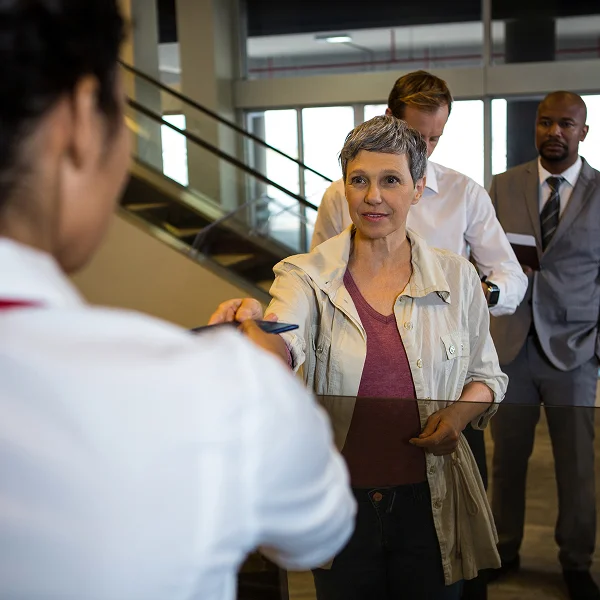 Une femme remet un stylo à un homme lors de l'organisation d'un congrès.