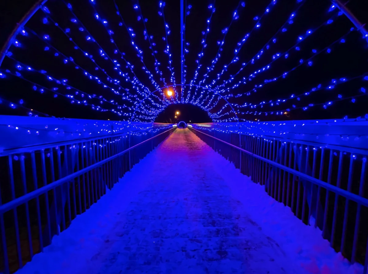 Capture-decran-le-2023-02-01-a-08.34.12-e1744219746152 Tunnel lumineux bleu avec guirlandes, chemin recouvert de neige, nuit noire, atmosphere magique.